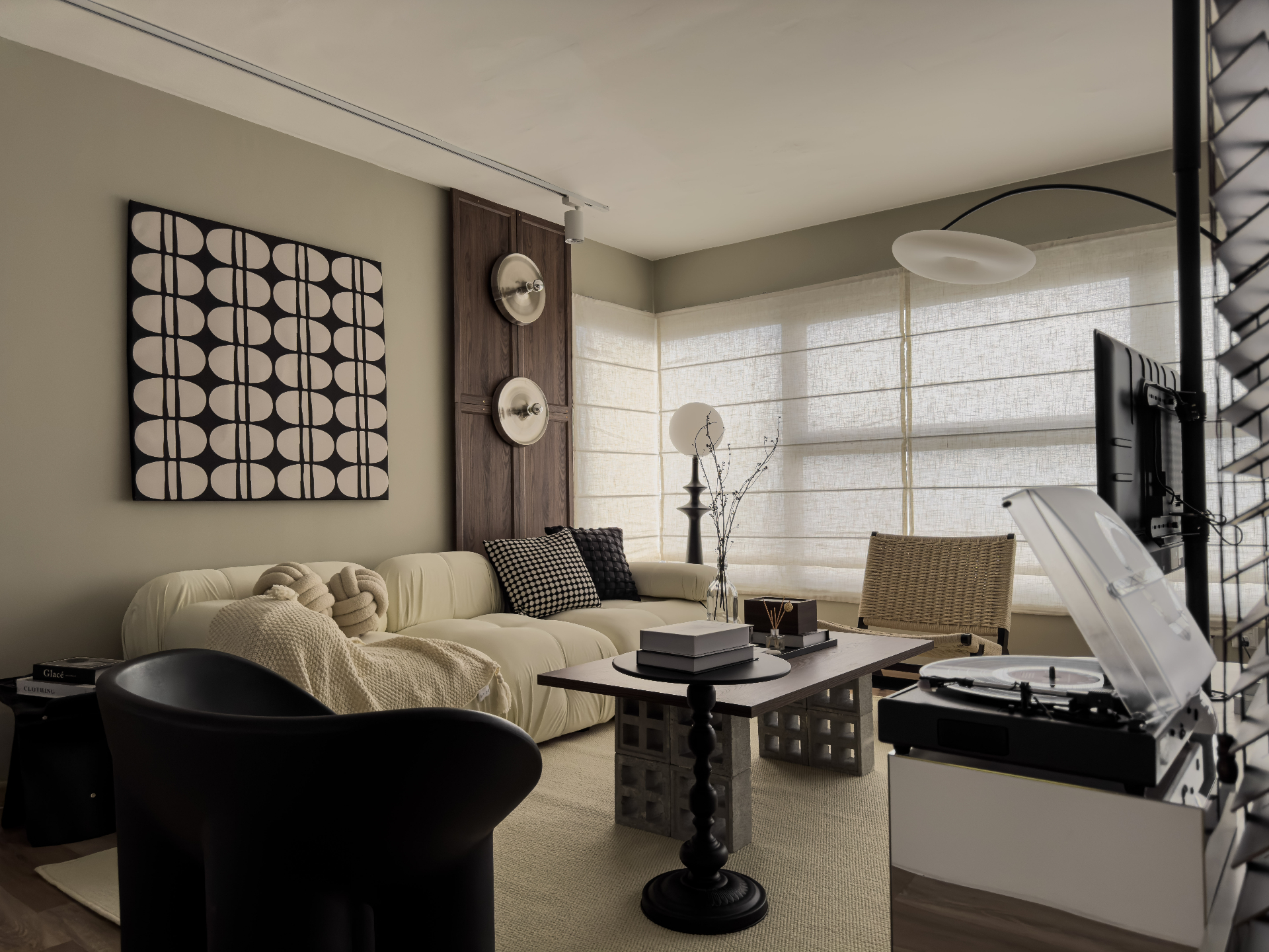 Maison Craft living room with bouclé modular sofa, graphic monochrome canvas, walnut sconces and vinyl turntable in warm linen light